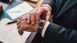 Especialista olhando o relógio e analisando documentos sobre tributação de dividendos em 2026.