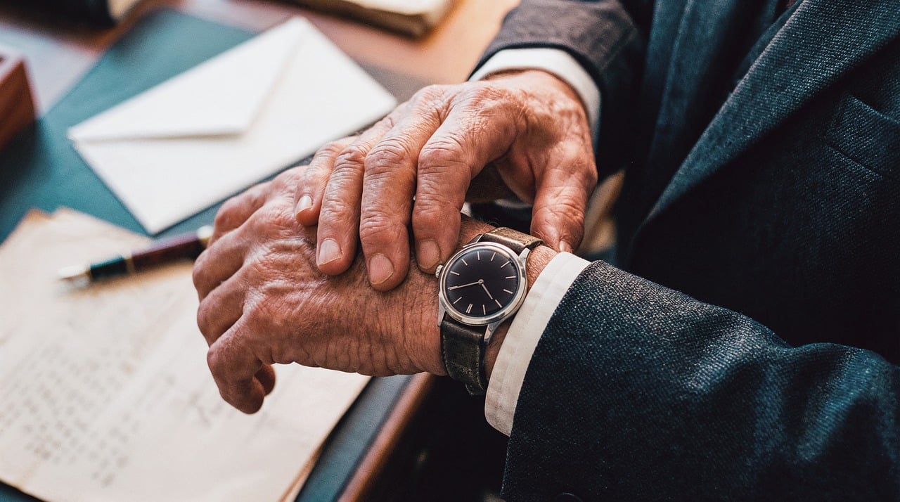 Especialista olhando o relógio e analisando documentos sobre tributação de dividendos em 2026.